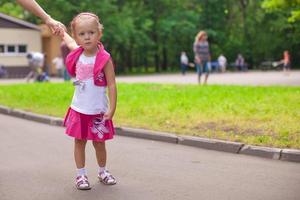 kleines Mädchen, das im Freien spazieren geht und Spaß im Park hat foto