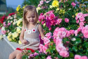 Porträt eines süßen kleinen Mädchens in der Nähe der Blumen im Hof ihres Hauses foto