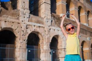 Mädchen mit kleinem Spielzeugmodellflugzeug auf Colosseo-Hintergrund in Rom, Italien foto