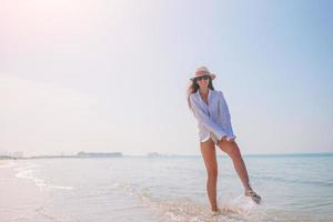 Frau, die am Strand liegt und die Sommerferien genießt foto