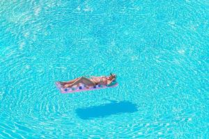 schöne junge frau, die im schwimmbad sich entspannt. foto