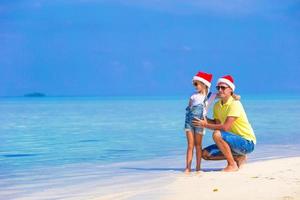 kleines mädchen und glücklicher vater in weihnachtsmützen genießen weihnachtsferien foto