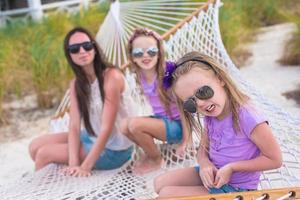 mutter und kleine töchter entspannen sich im sommerurlaub in der hängematte foto