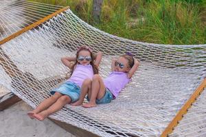 kleine süße Mädchen, die sich im Sommerurlaub in der Hängematte entspannen foto
