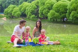 glückliche Familie, die im Park picknickt foto