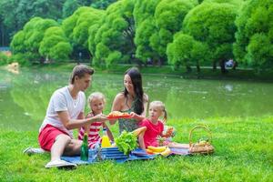 glückliche junge familie, die draußen picknickt foto