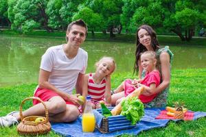 glückliche Familie, die im Park picknickt foto