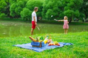 glückliche Familie, die im Park picknickt foto