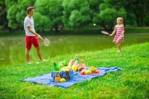 glückliche Familie, die im Park picknickt foto