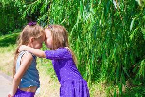 Fröhliche entzückende kleine Mädchen genießen den Sommertag im Park foto