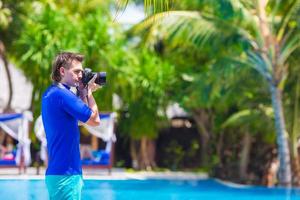 junger Mann, der Landschaft auf einer tropischen Insel fotografiert foto
