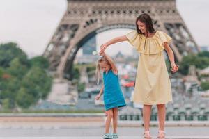 Kleines entzückendes Mädchen und ihre junge Mutter in Paris in der Nähe des Eiffelturms während der Sommerferien foto