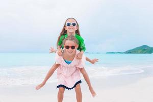 kleine glückliche kinder haben viel spaß am tropischen strand, der zusammen spielt foto