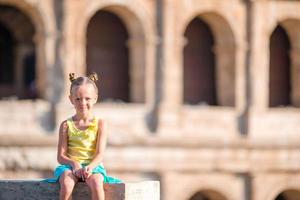 entzückender hintergrund des kleinen mädchens des kolosseums in rom, italien. kind verbringt urlaub in europa foto