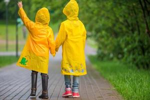 entzückende kleine Mädchen unter dem Regen an einem warmen Herbsttag foto