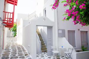Die engen Gassen mit blauen Balkonen, Treppen, weißen Häusern und Blumen im schönen Dorf in Griechenland. schöne architektur gebäude außen mit kykladischem stil in mykonos