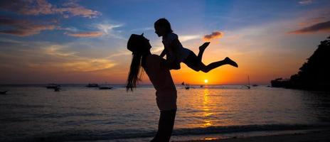 Kleines Mädchen und ihre Mutter amüsieren sich bei Sonnenuntergang auf der Insel Boracay, Philippinen