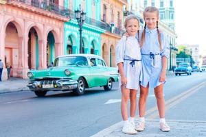 entzückendes kleines Mädchen in der beliebten Gegend in der Altstadt von Havanna, Kuba. Porträt von zwei Kindern im Freien auf einer Straße von Havanna foto