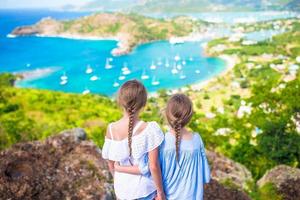 Entzückende kleine Kinder, die den Blick auf den malerischen englischen Hafen von Antigua in der Karibik genießen foto