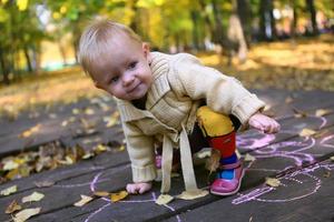 Porträt eines kleinen entzückenden Mädchens, das allein im Herbstpark spazieren geht foto