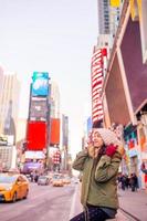 new york city frau als time square tourist oder junge glückliche frau, die manhattan, new york city, new york, usa besucht. foto