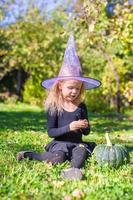 süßes kleines Mädchen in Halloween, welches Kostüm Spaß im Freien hat foto