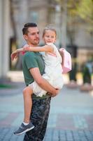glücklicher Vater und kleines entzückendes Mädchen in der Stadt im Freien foto