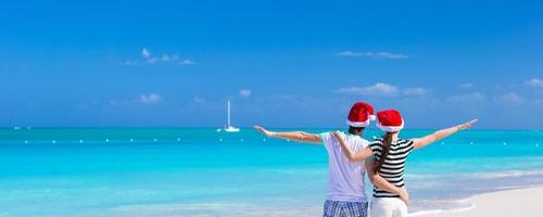 junges romantisches paar in weihnachtsmützen während des strandurlaubs foto