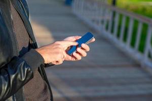 Nahaufnahme der Hände des Mannes mit Handy im Freien foto