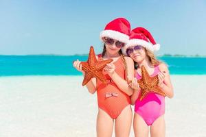 entzückende kleine Mädchen in den Weihnachtsferien am Strand foto