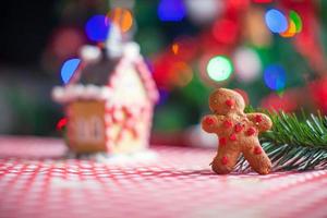 Lebkuchenmann Hintergrund Süßigkeiten Ingwer Haus und Weihnachtsbaum Lichter foto
