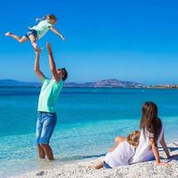 vierköpfige Familie, die Spaß während ihres tropischen Urlaubs hat foto