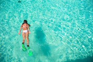 junge Frau, die im Urlaub im tropischen Wasser schnorchelt foto