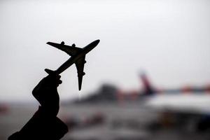 Schattenbild eines kleinen Flugzeugmodells auf Flughafenhintergrund foto