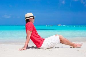 junger Mann, der Sommerferien am tropischen Strand genießt foto