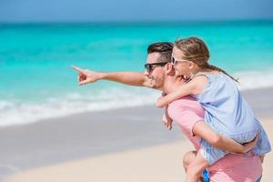 kleines mädchen und glücklicher vater, der spaß während des strandurlaubs hat foto