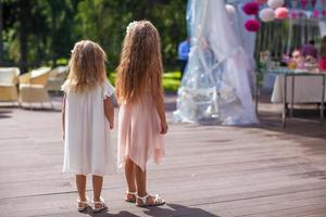 Zwei süße kleine Mädchen in wunderschönen Kleidern bei der Hochzeitszeremonie foto