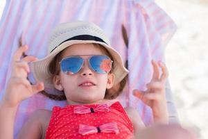 entzückendes kleines Mädchen auf Strandliege, das Spaß hat. Porträt eines süßen Mädchens im Strandurlaub foto