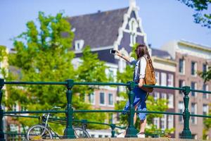 junge Touristin, die Selbstporträt-Selfie-Foto auf Europa-Reise in der Stadt Amsterdam macht foto