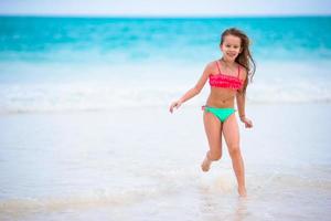 entzückendes kleines Mädchen am Strand während der Sommerferien foto