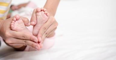 Muttererziehung und neugeborenes Geburtsleben. mutter und baby spielen im sonnigen schlafzimmer, familie hat spaß zusammen. kinderbetreuung, mutterschaftskonzept. foto