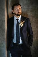 porträt eines männlichen bräutigams in einem blauen anzug im morgenfriseursalon foto