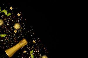 festliches partykonzept, champagner mit band und weihnachtsgoldkugel mit konfetti bunten sternen foto