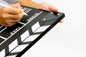 die hand hält clapperboard oder filmschieferschwarze farbe und markierungsstift. konzept der kinoindustrie. foto