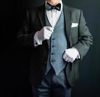 Porträt von Butler für Concierge in dunklem Anzug und weißen Handschuhen. konzept der dienstleistungsbranche und der professionellen gastfreundschaft. foto