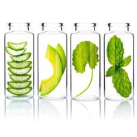 Hausgemachte Hautpflege mit natürlichen Inhaltsstoffen Avocado, Aloe Vera, Centella Asiatica und Minzblättern in Glasflaschen isolieren auf weißem Hintergrund. foto