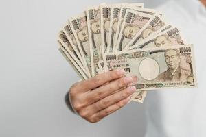 Hand des Mannes, die einen Stapel japanischer Yen-Banknoten hält. Tausend Yen Geld. japanische bargeld-, steuer-, rezessionswirtschafts-, inflations-, investitions-, finanz- und einkaufszahlungskonzepte foto