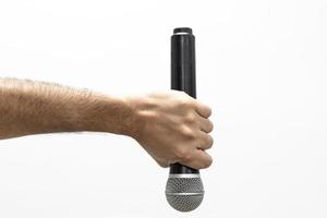 Hand, die Mikrofon auf weißem Hintergrund hält foto