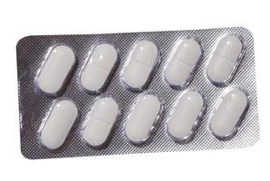 Ovale weiße Pillen in einer grauen Blisterpackung auf weißem Hintergrund foto