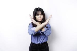 schöne asiatische frau, die blaues hemd mit handgeste trägt, stellt ablehnung oder verbot mit kopienraum dar foto